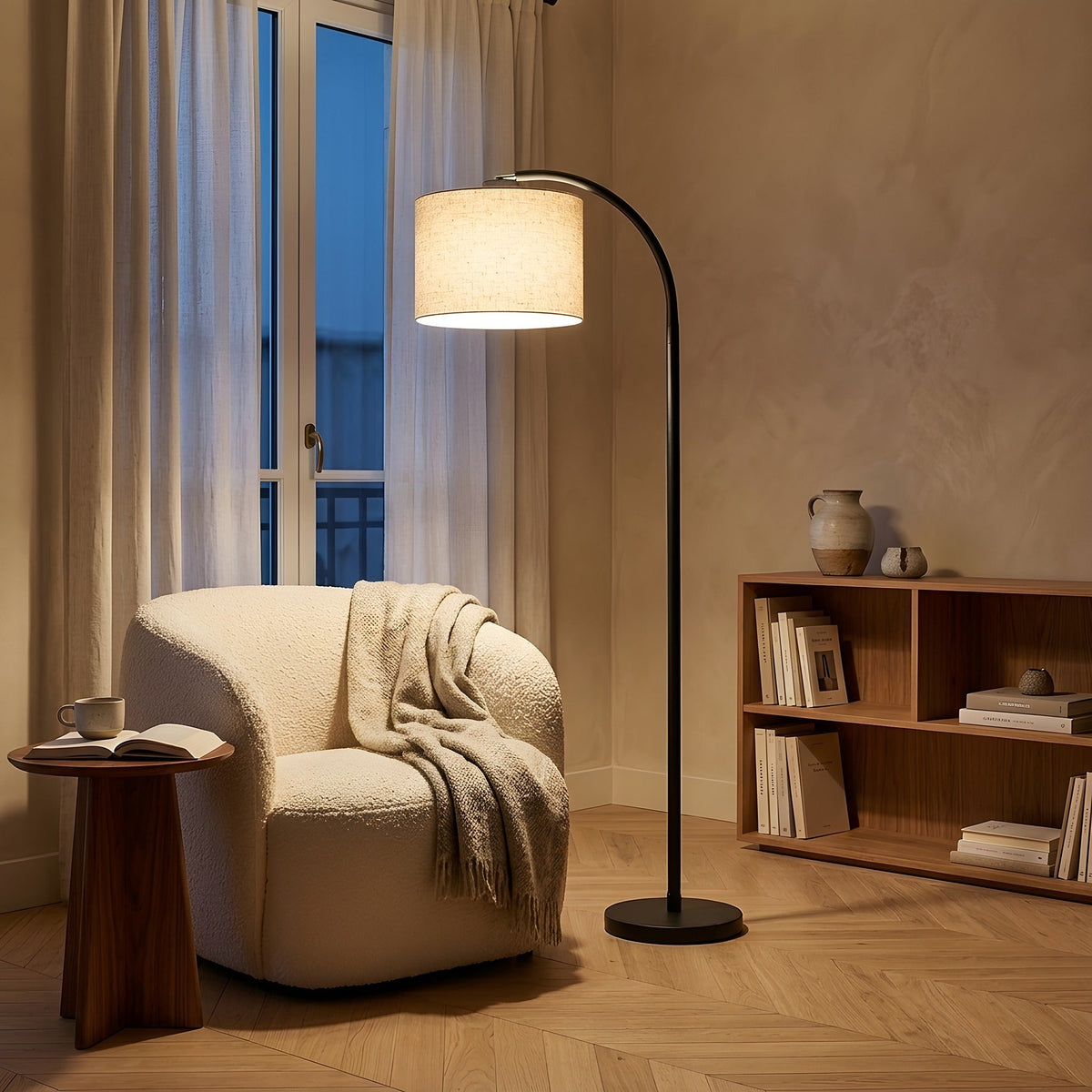 Coin lecture le soir, lampadaire arc à abat-jour en lin allumé près d'un fauteuil en bouclé