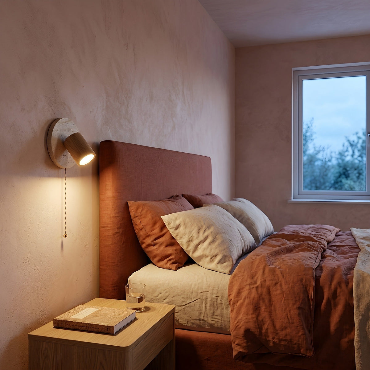 Chambre à l'heure bleue éclairée par une applique en travertin à la lumière chaude